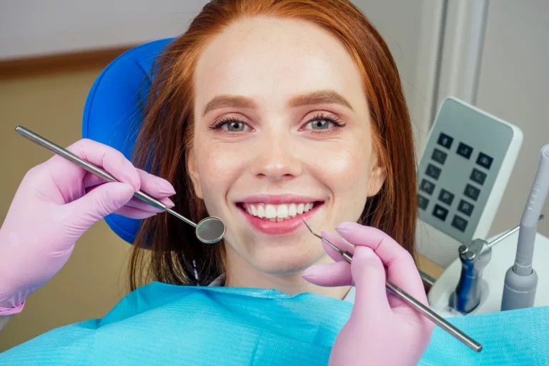 portrait of an attractive smiling redhaired ginger customer girl in a dental chair