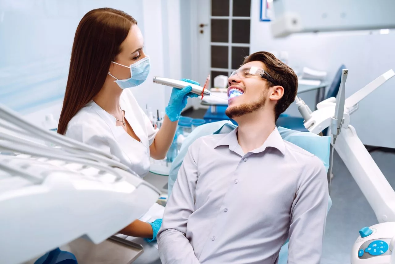 young man at the dentist s chair during a dental procedure overview of dental caries prevention